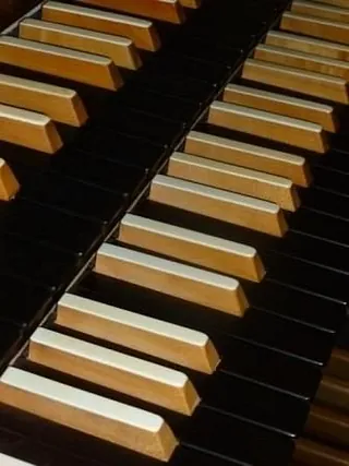 Holz- und schwarze Tasten einer Kirchenorgel.
