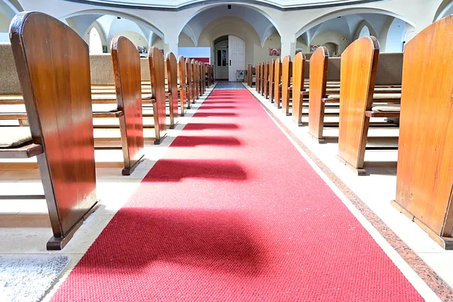 Leeres Kircheninneres, Sonnenlicht auf rotem Teppich.