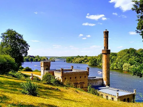 Verziertes historisches Gebäude am Wasser, kirchlich anmutend.