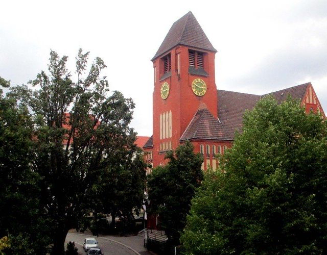  Historische Backsteinkirche mit Uhrenturm, teilweise verdeckt.