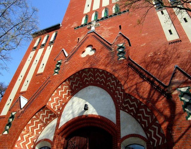 Verzierte rote Backsteinkirche, detaillierter Torbogen.