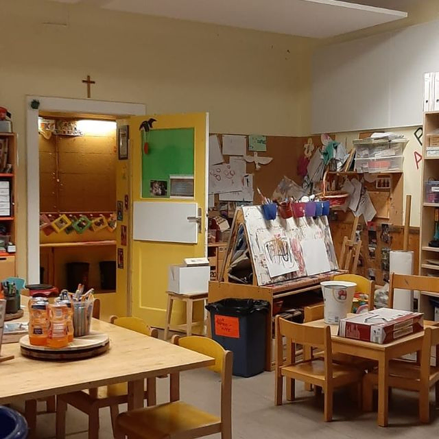 Kinderspielzimmer mit Rutsche, Schaukelpferd und Teddybär.