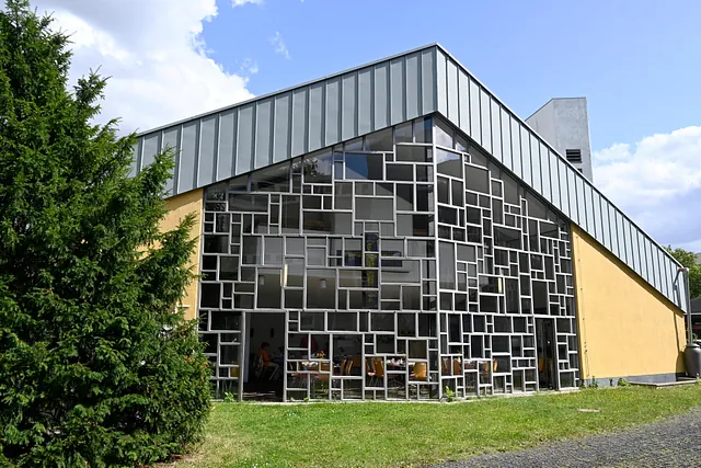 Modernes Kirchengebäude mit geometrischer Fenstergestaltung.