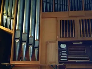 Seitenansicht von Kirchenorgelpfeifen und Spieltisch.