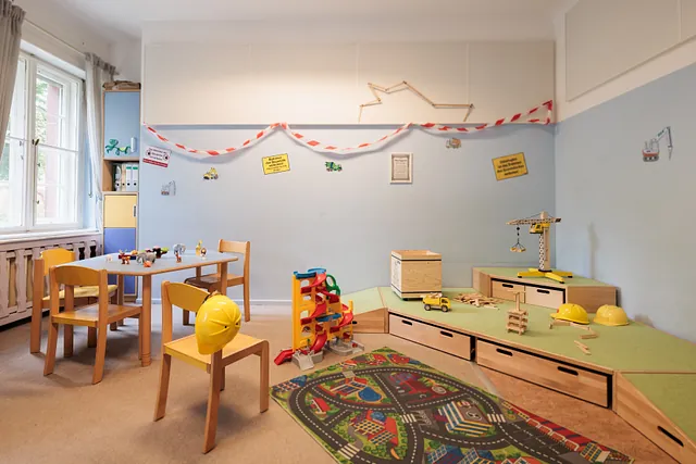Kinderspielbereich mit Bauspielzeug und einem Straßen-Teppich.